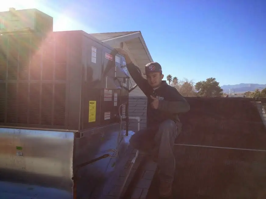 HVAC technician performing Boiler Repair on a rooftop unit in Festus